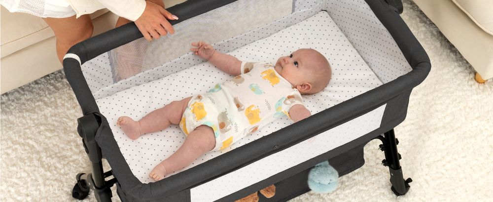 Baby asleep on the mattress of a Dark Grey BCOL bassinet